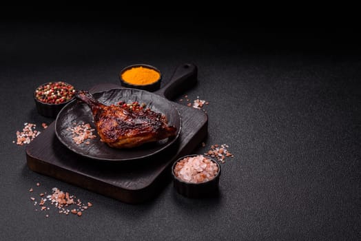 Duck, chicken leg or thigh grilled on a dark concrete background. Duck confit, Asian food with salt and spices