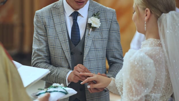 Groom placing a wedding ring on the bride's finger during a heartfelt ceremony, symbolizing their love and commitment on this special day