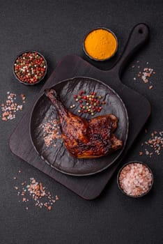 Duck, chicken leg or thigh grilled on a dark concrete background. Duck confit, Asian food with salt and spices