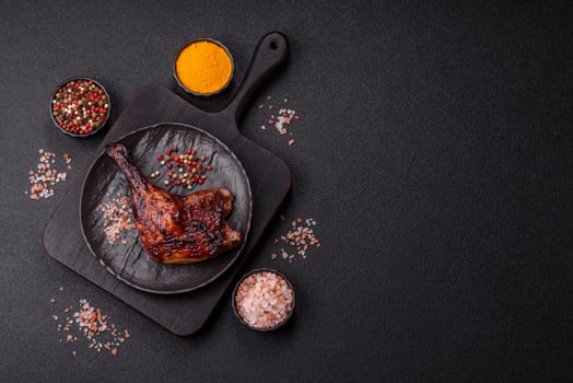 Duck, chicken leg or thigh grilled on a dark concrete background. Duck confit, Asian food with salt and spices