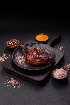Duck, chicken leg or thigh grilled on a dark concrete background. Duck confit, Asian food with salt and spices