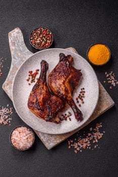 Duck, chicken leg or thigh grilled on a dark concrete background. Duck confit, Asian food with salt and spices