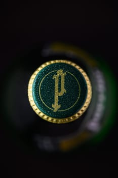 Gaziveren Cyprus -24.03.2025 A close-up view of a green bottle water Perrier cap adorned with a yellow emblem, glistening with moisture. This detailed perspective invites thoughts of refreshing drinks during festive moments.