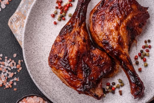 Duck, chicken leg or thigh grilled on a dark concrete background. Duck confit, Asian food with salt and spices