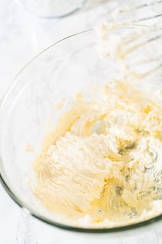 In a large mixing bowl, the ingredients are expertly mixed to create a delectable cream cheese buttercream for the Carrot Bundt Cake.