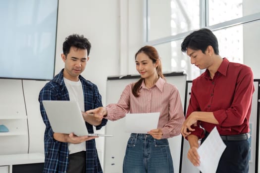 In a vibrant office setting, team members focus on new design trends as they analyze reports and visuals, demonstrating teamwork and a shared commitment to innovative solutions.