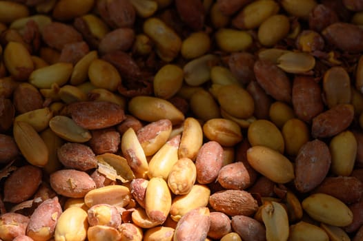 A rich collection of raw peanuts in various colors rests under gentle sunlight, showcasing their natural textures and imperfections. Serenity reigns in this botanical haven.