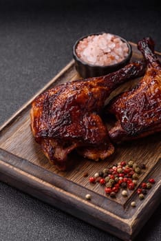 Duck, chicken leg or thigh grilled on a dark concrete background. Duck confit, Asian food with salt and spices