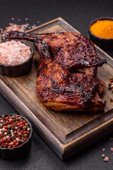 Duck, chicken leg or thigh grilled on a dark concrete background. Duck confit, Asian food with salt and spices