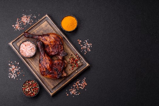 Duck, chicken leg or thigh grilled on a dark concrete background. Duck confit, Asian food with salt and spices