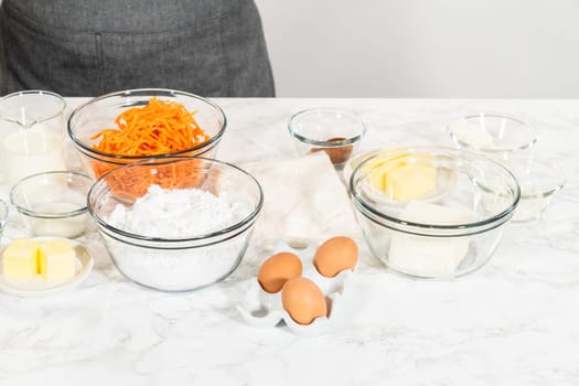 The measured ingredients are placed in mixing bowls on the counter, preparing to bake a scrumptious Carrot Bundt Cake from a cake mix.