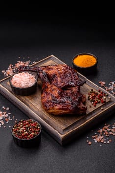 Duck, chicken leg or thigh grilled on a dark concrete background. Duck confit, Asian food with salt and spices