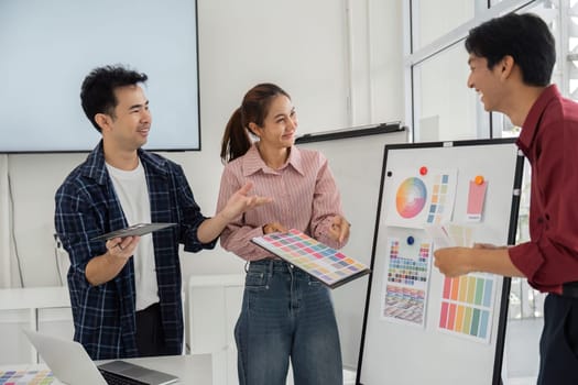 In a lively environment, team members enthusiastically exchange opinions on color choices for their design project.