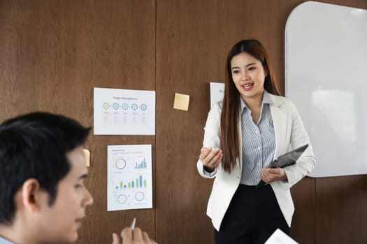 A business meeting focuses on project management as a professional engages with the team, sharing insights and fostering collaboration through effective communication.