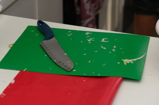 A vibrant kitchen comes alive as fresh vegetables are chopped on a green cutting board. A sharp knife lays nearby, ready to create a delicious culinary masterpiece in progress.