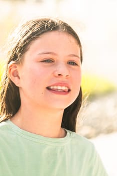 A joyful young girl gleefully gets soaked in refreshing water mist during a hot summer day.
