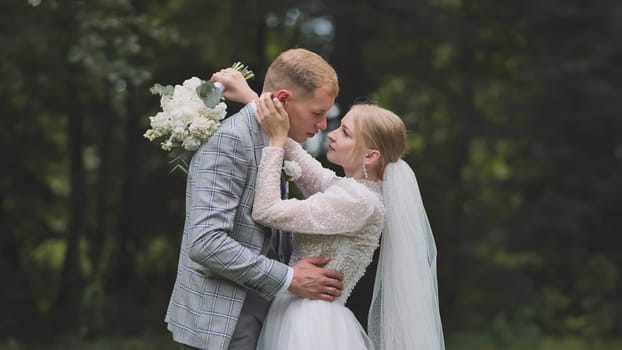 Newlywed couple embracing in forest setting, celebrating their wedding day with love and tenderness