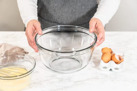 In the process of creating mouthwatering chocolate cupcakes, the first step involves meticulously mixing the ingredients in a glass mixing bowl to make the perfect batter.