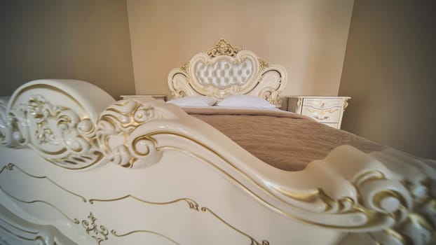 Luxurious bed featuring white and gold ornate carvings, creating an elegant and romantic atmosphere in a bedroom, ideal for a wedding day celebration