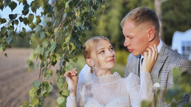 Newlywed couple sharing a tender moment under a birch tree, celebrating their love and commitment on their wedding day