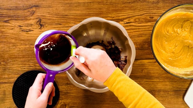 Flat lay. Carefully greasing a bundt cake pan in preparation for baking a delicious gingerbread bundt cake with caramel frosting.