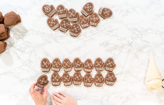Rows of both decorated and plain mitten cookies are arranged together, highlighting the transition from unadorned to beautifully iced holiday cookies.