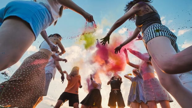 Group of young students throwing colored powder in the air, celebrating the end of school
