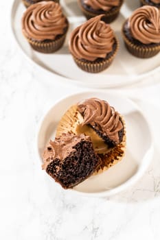 A delectable chocolate cupcake, sliced in half, elegantly presented on a plate.