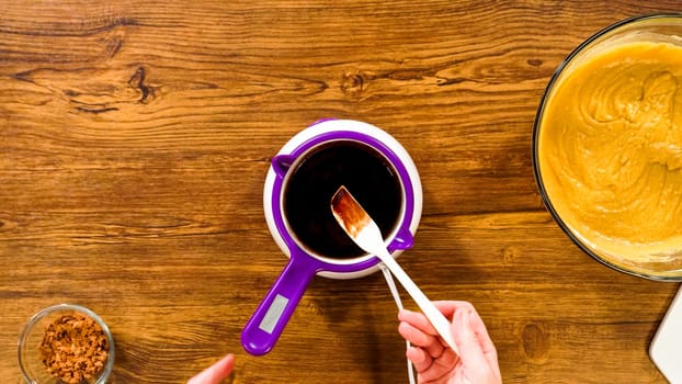 Flat lay. Carefully greasing a bundt cake pan in preparation for baking a delicious gingerbread bundt cake with caramel frosting.