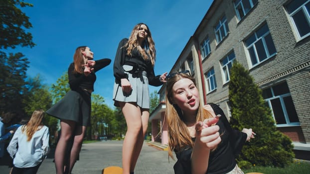 Three happy high school girls happily pointing and having fun together on a bright school day, honoring their friendship and love for learning