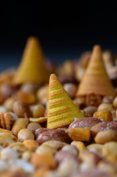 Colorful cones stand tall amid a sea of various nuts, evoking a playful atmosphere. This vibrant display showcases contrasting textures and hues, inviting exploration and creativity.
