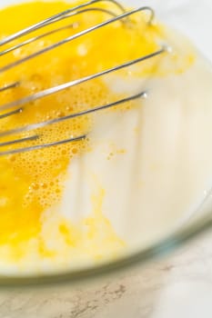 In the process of creating mouthwatering chocolate cupcakes, the first step involves meticulously mixing the ingredients in a glass mixing bowl to make the perfect batter.