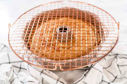 The freshly baked Carrot Bundt Cake is left to cool on the kitchen counter, filling the air with delightful aromas.