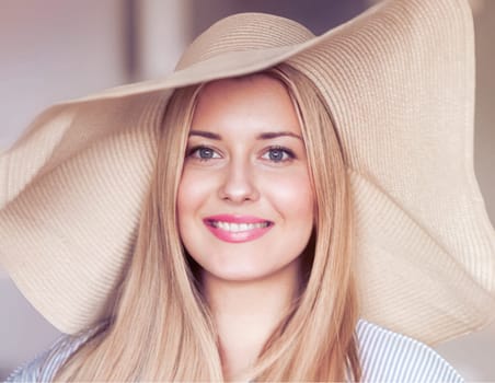 Woman, fashion and summer country charm, blonde beauty and elegance in wide brimmed beach hat. Feminine allure, timeless style and graceful glow. Smile, straw hat and blue striped blouse, natural lighting and effortless charm, fashion look idea