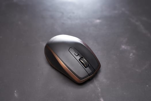 Wireless mouse lies on a black table. Top view. High quality photo