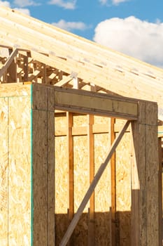 An ongoing construction site in the suburbs, featuring the framing stage of a single-family house.