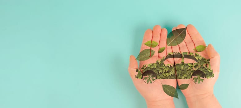 Holding a green electric car made from leaves, sustainable and renewable ressources, eco power, environment issue, generative AI used for the car