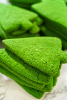A stack of plain green Christmas tree cookies, emphasizing their vibrant green color and smooth texture.