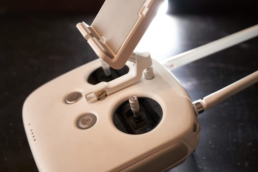 DJI Phantom 3 drone remote control stands on a black table. Side view. High quality photo
