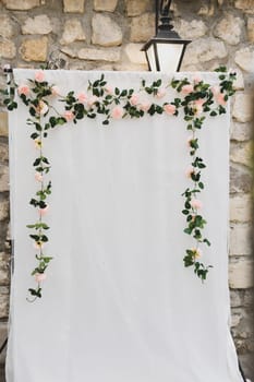 Arch decoration of flowers on white fabric background for photographing newlyweds and guests