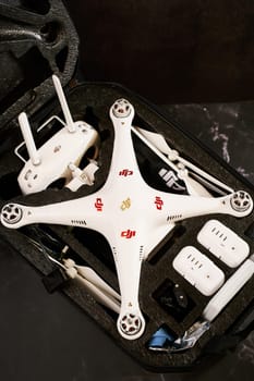 Complete set of DJI Phantom Professional drone with spare parts lies in a protective case on a black table. High quality photo