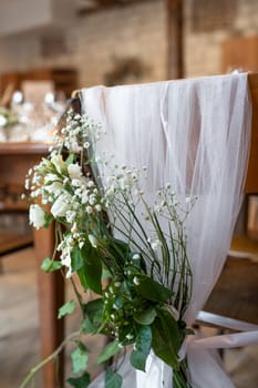 Wedding chairs decorated with white cloth and flowers