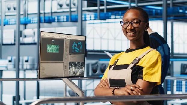 Portrait of joyous smart solar panels manufacturing factory expert working on predictive maintenance algorithms. Smiling african american woman in industry 4.0 plant overseeing facility floor
