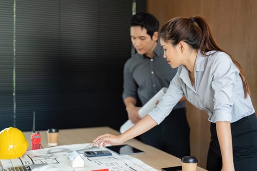 Engineers concentrate on project blueprints and data, ensuring thorough analysis for successful execution of their plans.