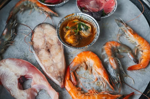 Seafood is grilled at buffet in an Asian restaurant in Asia in Vietnam. Pieces of fish and shrimp are fried on the stove