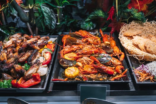hot dishes garnish at Asian buffet in hotel in restaurant for breakfast. Fried chicken meat and crayfish at the Asian night market in Vietnam