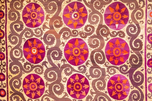 traditional Uzbek pattern on an ancient handmade carpet in Uzbekistan. Oriental background with beautiful ornaments