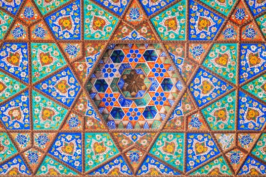 colorful background of carved wooden painted ceiling in the Museum of Art of Uzbekistan with traditional Uzbek ornaments and oriental patterns in Tashkent