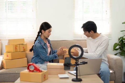 The duo sorts through their packaged products, brainstorming ideas on how to best present them for their online customers, capturing the essence of entrepreneurial spirit.