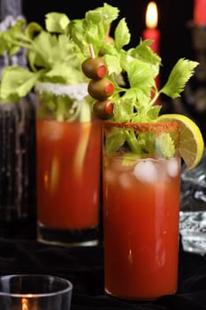 Bloody Mary cocktail. Tomato juice and vodka, garnished with celery stalk, lime and olives. Halloween party ideas